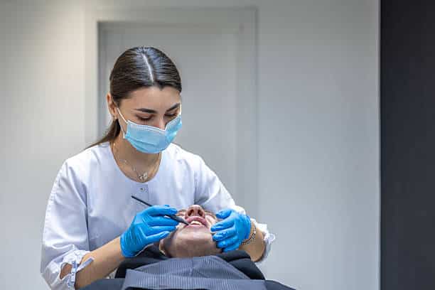 Dentist performing a gentle examination, patient relaxed in the chair.